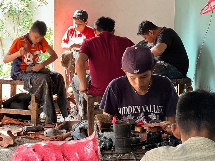 Jovenes aprendiendo a elaborar zapatos