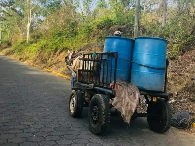 Una carreta, en ella se observan dos barriles que servirán para transportar agua